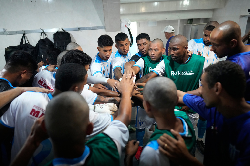 Players of Originarios, a new team in Rio's fifth division made up exclusively of Indigenous players, gather in the dressing room before a match against Barcelona in Rio de Janeiro, Sunday, May 3, 2026. (AP Photo/Silvia Izquierdo)