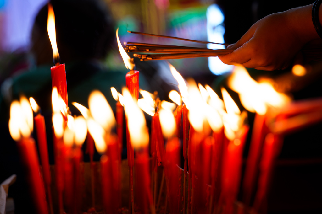 Ethnic Chinese devotees light incense sticks as they pray before a paper statue of Da Shi Ye, the Guardian God of Ghosts, during the Hungry Ghost Festival in Bukit Metajam, Malaysia, Saturday, Aug. 29, 2026. (AP Photo/Vincent Thian)