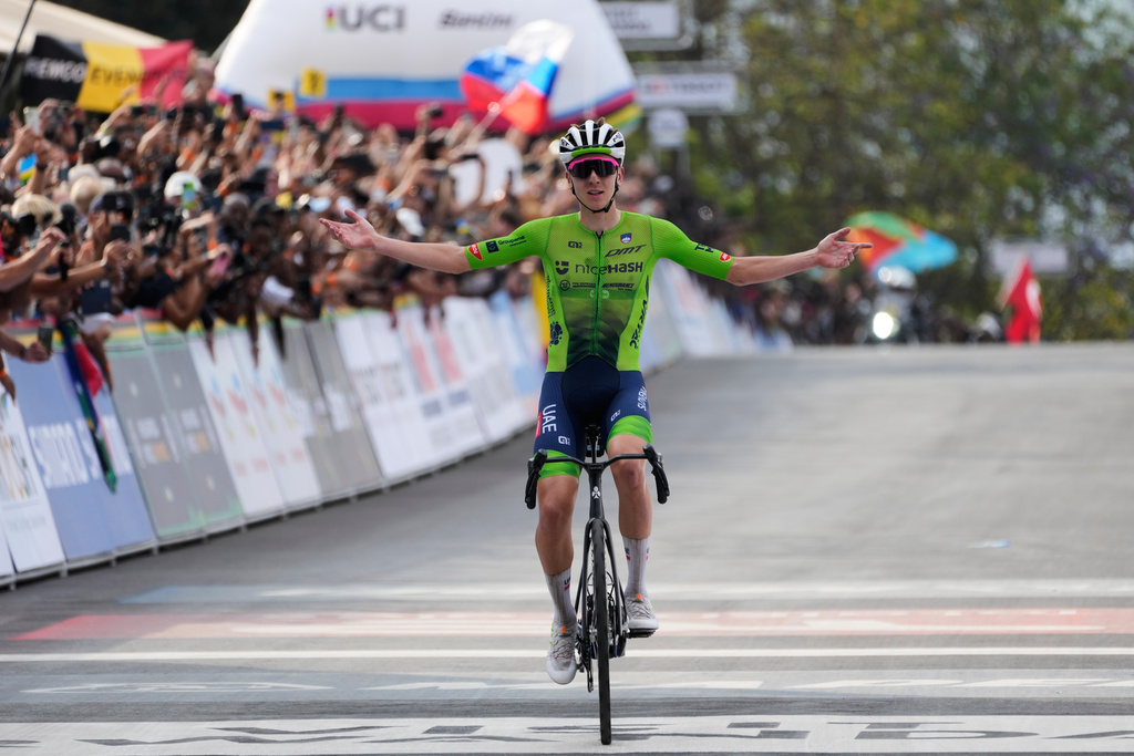 Slovenia's Tadej Pogacar celebrates winning the men's Elite road race, at the road cycling World Championships in Kigali, Rwanda, Sunday, Sept. 28, 2025. (AP Photo/Jerome Delay)