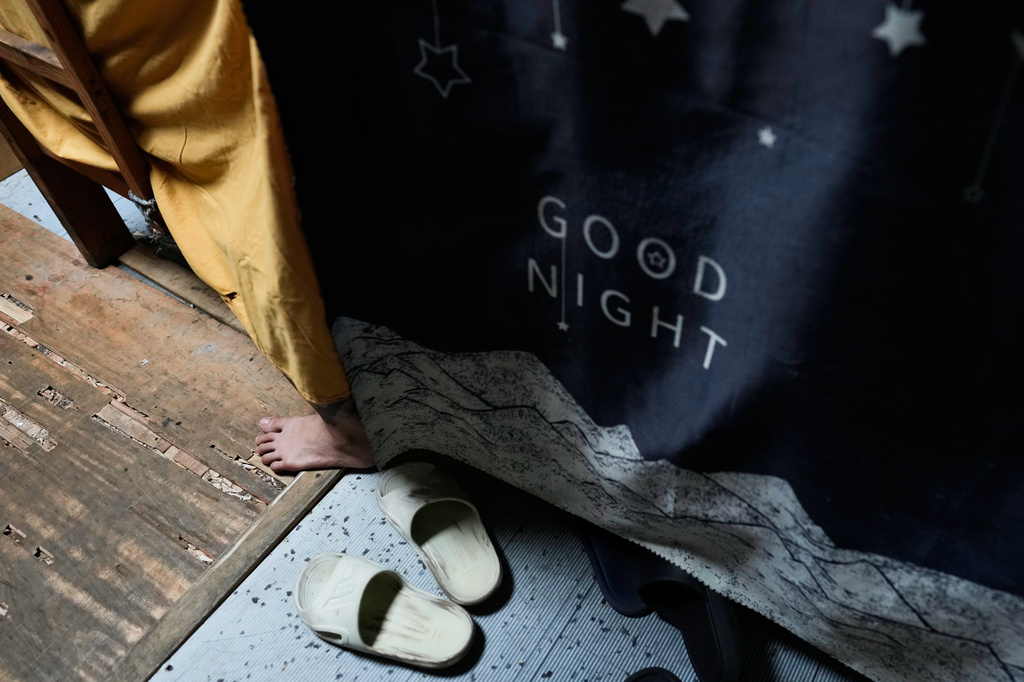 A rescued Vietnamese scam worker rests inside his room at the Presidential Anti-Organized Crime Commission temporary detention center, a former scam compound in Pasay, Philippines, Tuesday, June 3, 2025. (AP Photo/Aaron Favila)
