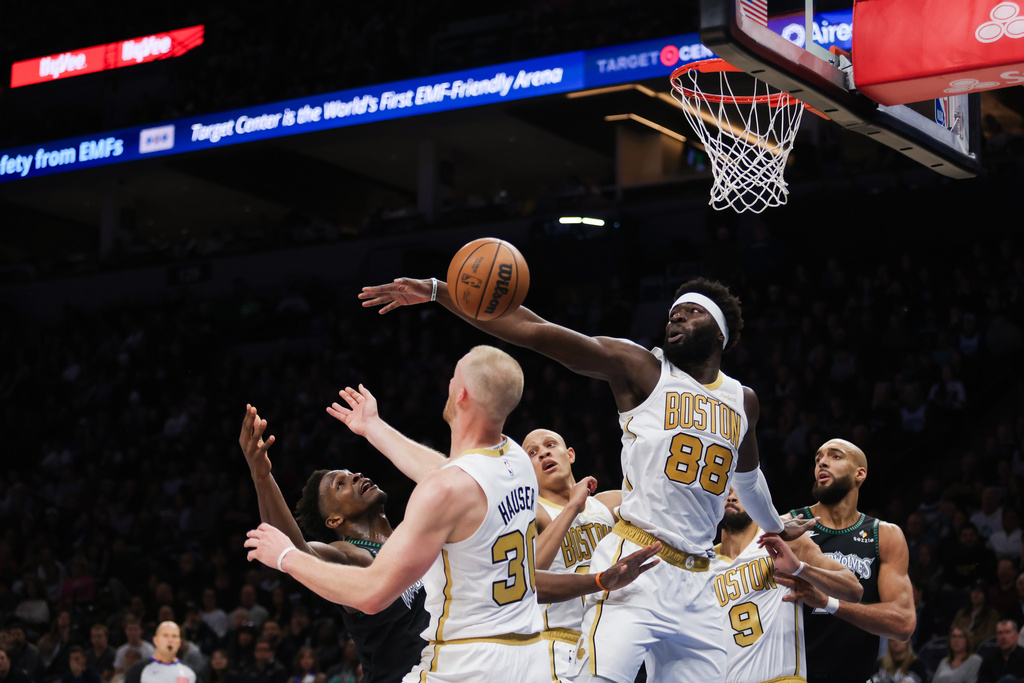 Boston Celtics' Neemias Queta (88) blocks a shot by Minnesota Timberwolves' Anthony Edwards (5) during the first half of an NBA basketball game, Saturday, Nov. 29, 2025, in Minneapolis. (AP Photo/Lily Dozier)