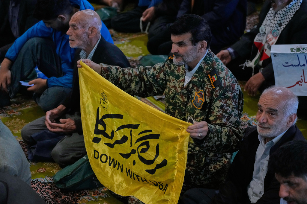 An Iranian worshipper holds an anti-U.S. banner during Friday prayers ceremony at the Tehran University campus, in Tehran, Iran, Friday, April 24, 2026. (AP Photo/Vahid Salemi)