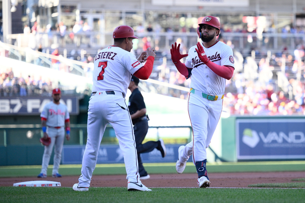 Washington Nationals' Luis Garcia Jr., right, celebrates his home run with third base coach Victor Estevez (7) during the first inning of a baseball game against the Philadelphia Phillies, Wednesday, June 24, 2026, in Washington. (AP Photo/Nick Wass)