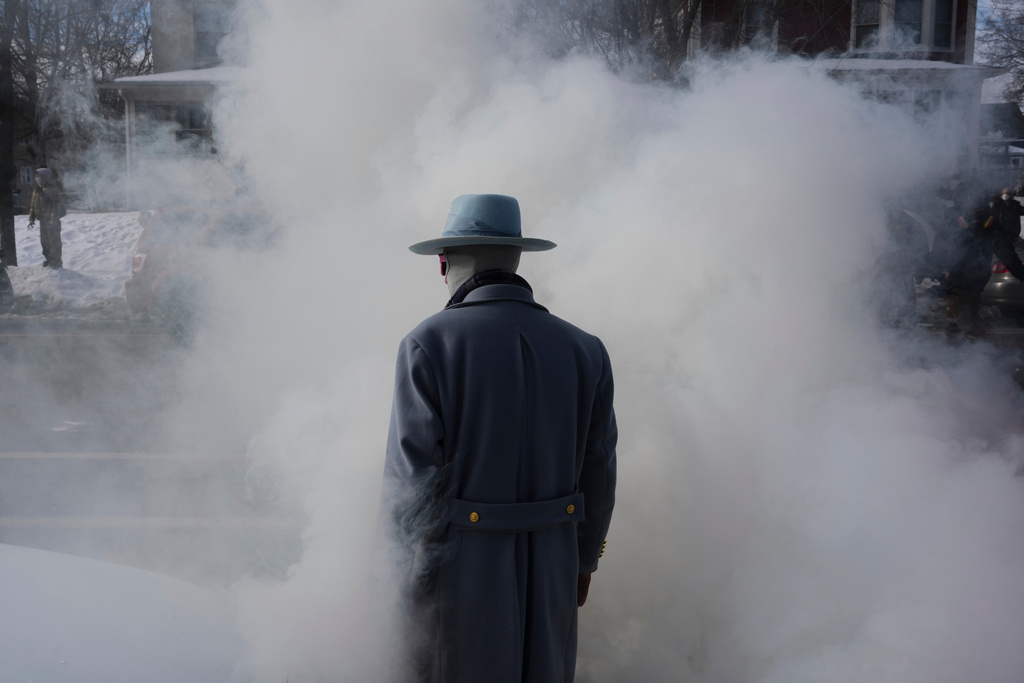 A man walks into smoke from tear gas dispersed by federal agents, during a protest, Monday, Jan. 12, 2026 in Minneapolis (AP Photo/Adam Gray)