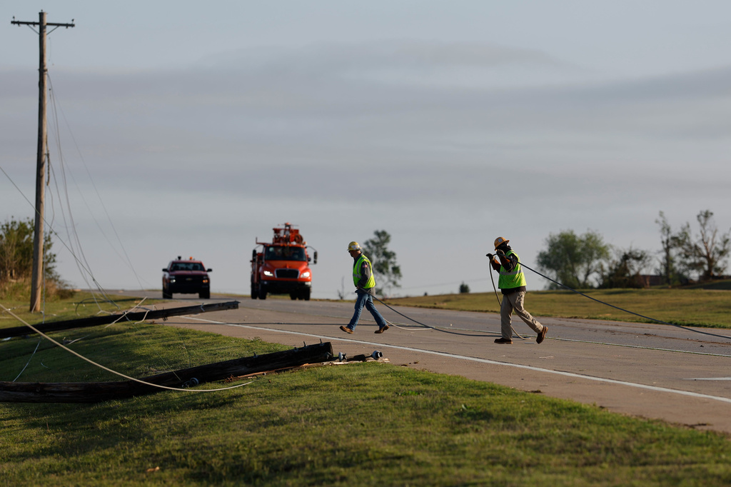 Electric crews remove down power lines in Enid, Okla., Friday, April 24, 2026, in the aftermath of a tornado that barreled through Oklahoma Thursday. (AP Photo/Alonzo Adams)