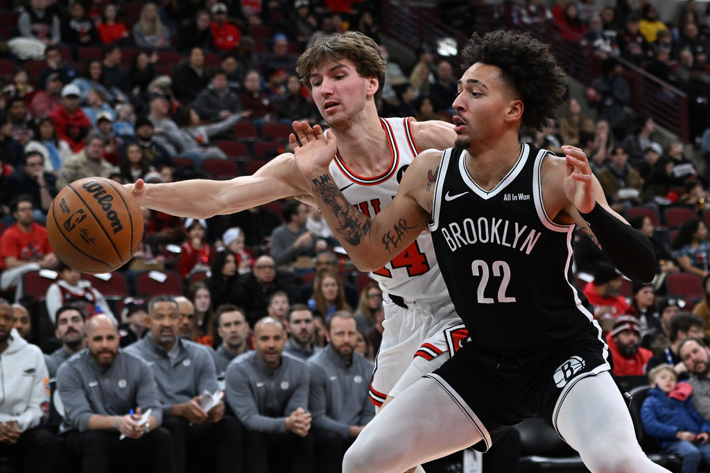 Brooklyn Nets' Jalen Wilson (22) battles Chicago Bulls' Matas Buzelis (14) for a loose ball during the first half of an NBA basketball game Sunday, Jan. 18, 2026, in Chicago. (AP Photo/Paul Beaty)