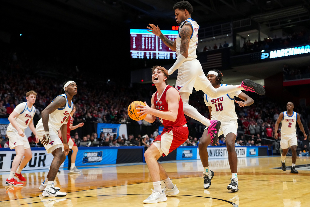 Miami (Ohio) guard Peter Suder, bottom center, is fouled by SMU forward Corey Washington, top, during the second half of a First Four college basketball game in the NCAA Tournament in Dayton, Ohio, Wednesday, March 18, 2026. (AP Photo/Jeff Dean)