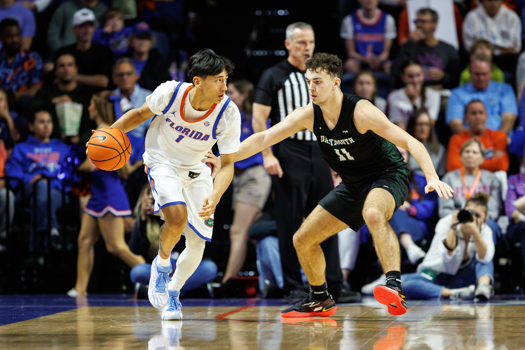 Florida guard Xaivian Lee (1) drives past Dartmouth guard Cam Hiatt (11) during the first half of an NCAA college basketball game Monday, Dec. 29, 2025, in Gainesville, Fla. (AP Photo/Chris Watkins)