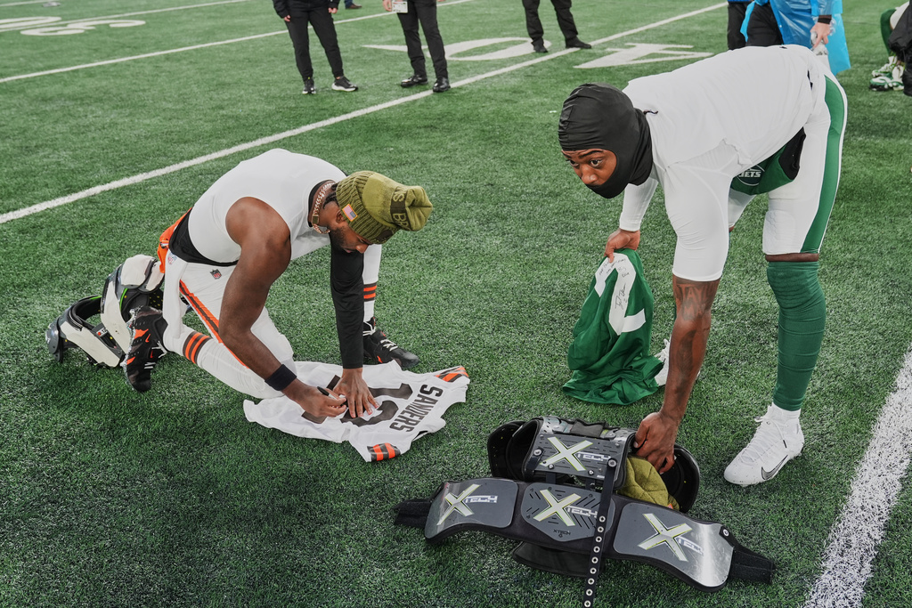 Cleveland Browns quarterback Shedeur Sanders, left, and New York Jets quarterback Tyrod Taylor, right, exchange jerseys after their NFL football game, Sunday, Nov. 9, 2025, in East Rutherford, N.J. (AP Photo/Seth Wenig)