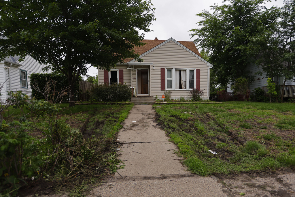 Tire marks from police vehicles mark the lawn of suspect Vance Luther Boelter's home in Minneapolis on Saturday, June 14, 2025. (AP Photo/Bruce Kluckhohn)
