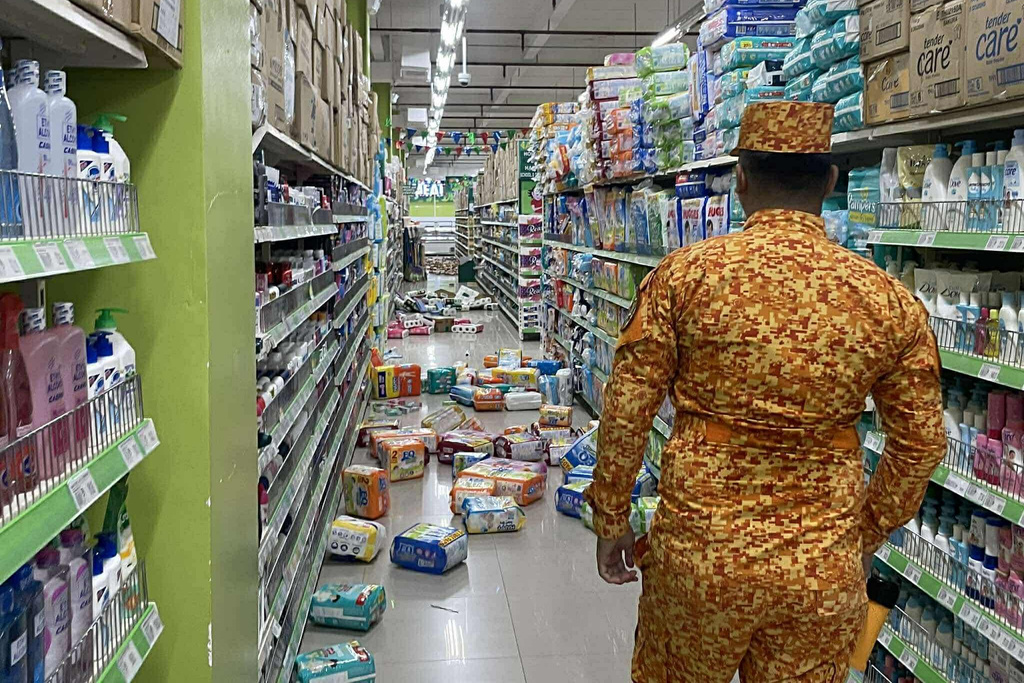 In this photo provided by the Bureau of Fire Protection, a fireman stands near the items on the floor at a grocery following a strong earthquake in Banaybanay, southern Philippines on Friday Oct. 10, 2025. (Bureau of Fire Protection via AP)