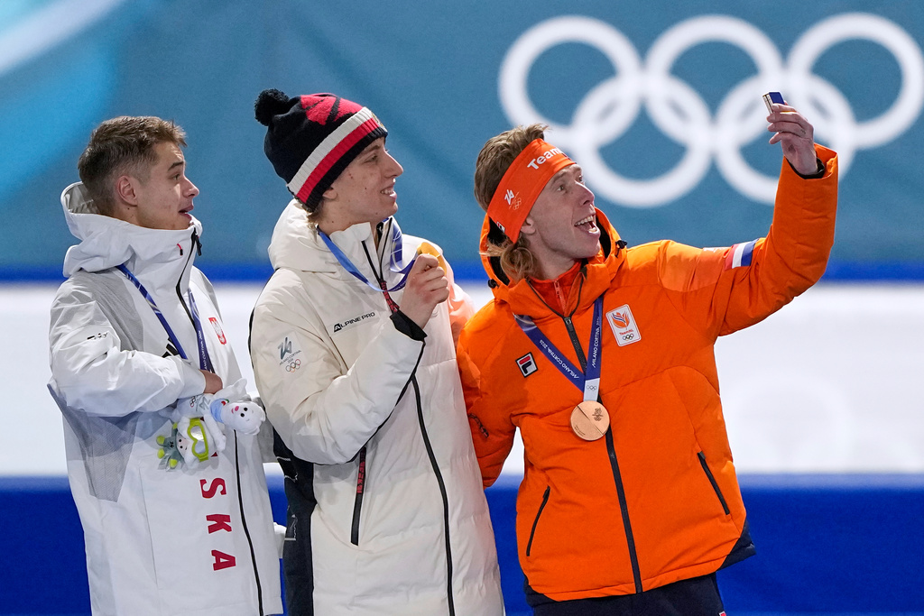 Gold medallist Metodej Jilek of Czechia, center, celebrates on the podium with Vladimir Semirunniy of Poland, left and silver medal, and Jorrit Bergsma of the Netherlands, right and bronze medal, after the men's 10,000 meters speedskating race at the 2026 Winter Olympics, in Milan, Italy, Friday, Feb. 13, 2026. (AP Photo/Ben Curtis)