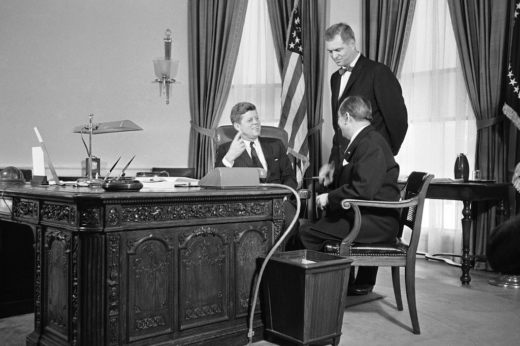 FILE - President John F. Kennedy gestures from behind a richly carved desk, made from the timbers of a British sailing ship, as he talks, Feb. 6, 1961 in his White House office in Washington with Mongi Slim, right, Tunisian Ambassador to the U.S., and G. Mennen Williams, Assistant Secretary of State for African Affairs. (AP Photo/HB, File)