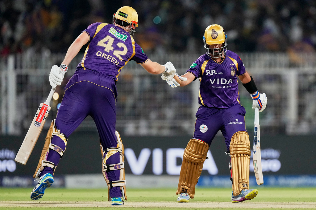 Kolkata Knight Riders' Cameron Green, left, and captain Ajinkya Rahane toss during the Indian Premier League cricket match between Delhi Capitals and Kolkata Knight Riders, in Kolkata , India, Sunday, May 24, 2026. (AP Photo/Bikas Das)