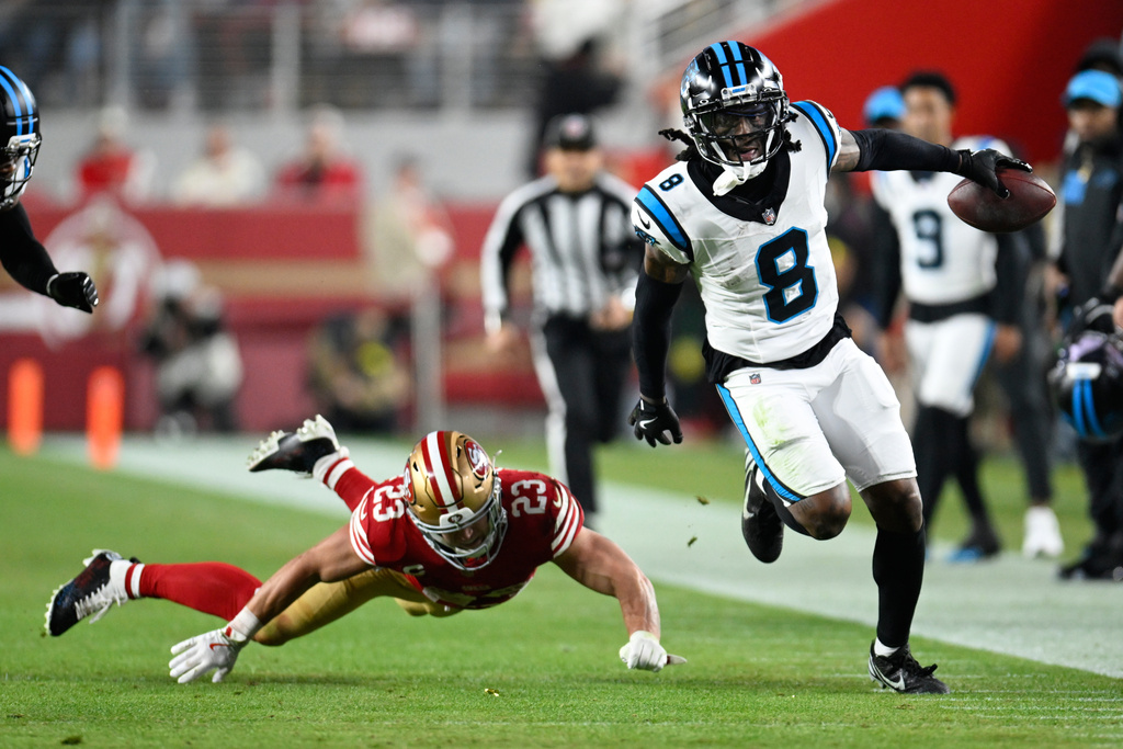 Carolina Panthers cornerback Jaycee Horn runs past San Francisco 49ers running back Christian McCaffrey afternoon an interception during the first half an NFL football game, Monday, Nov. 24, 2025, in Santa Clara, Calif. (AP Photo/Eakin Howard)