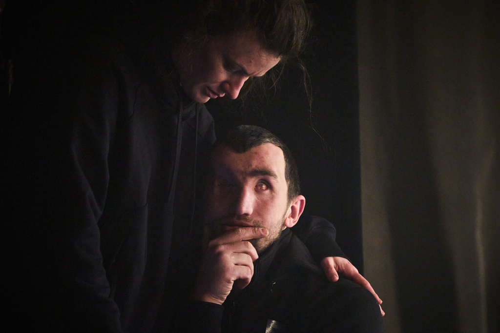 A woman supports Andrii Onopriienko, who was left blind from severe injuries he suffered in combat during Russia's full-scale invasion in Ukraine, before the premiere of an adaptation of Ivan Kotliarevskyi’s “Eneida,” a Ukrainian reimagining of Virgil’s “Aeneid,” in Kyiv, Ukraine, Thursday, Feb. 19, 2026. (AP Photo/Efrem Lukatsky)