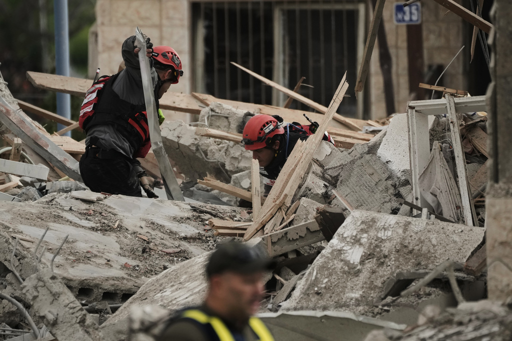 Rescue workers and military personnel operate at the scene where several people were killed in an Iranian missile strike in Beit Shemesh, Israel Sunday, March 1, 2026. (AP Photo/Leo Correa)