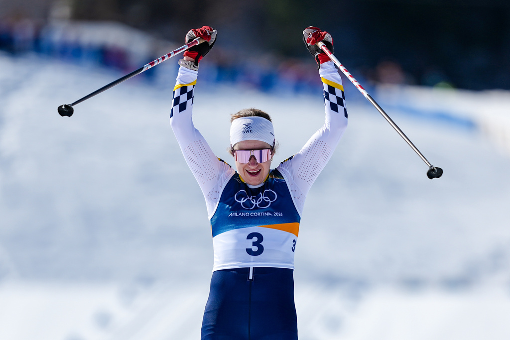 Ebba Andersson, of Sweden, crosses the finish line to win the gold medal in the cross country skiing women's 50km mass start classic at the 2026 Winter Olympics, in Tesero, Italy, Sunday, Feb. 22, 2026. (AP Photo/Matthias Schrader)