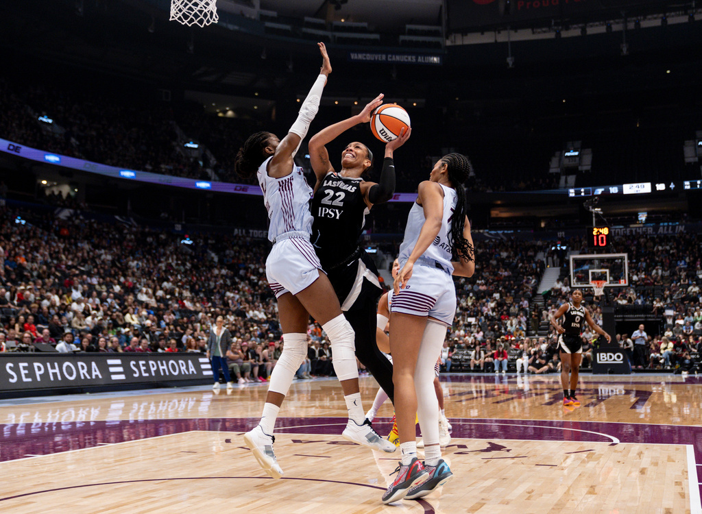 Las Vegas Aces' A'ja Wilson (22) drives to the basket as Toronto Tempo's Temi Fagbenle, left, and Toronto Tempo's Teonni Key, right, defend during the first half of a WNBA basketball game in Vancouver, British Columbia, Sunday, Aug. 23, 2026. (Jacob Mallari/The Canadian Press via AP)