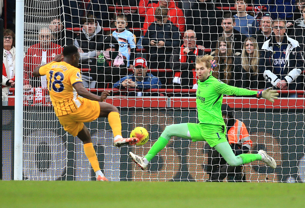 Brighton and Hove Albion's Danny Welbeck scores their side's second goal of the game past Brentford's goalkeeper Caoimhin Kelleher during their English Premier League soccer match in London Saturday, Feb. 21, 2026. (Peter Tarry/PA via AP)