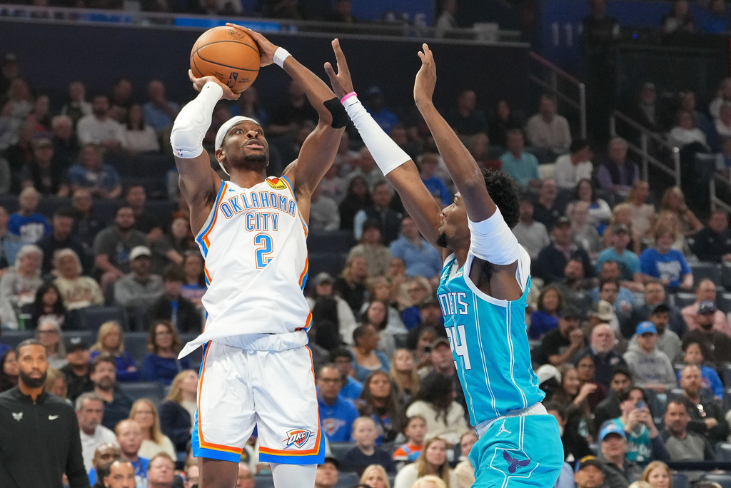 Oklahoma City Thunder guard Shai Gilgeous-Alexander, left, looks to shoot over Charlotte Hornets forward Brandon Miller, right, during the first half of an NBA basketball game, Monday, Jan. 5, 2026, in Oklahoma City. (AP Photo/Kyle Phillips)