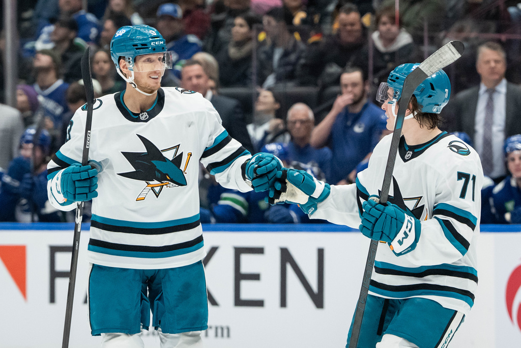 San Jose Sharks' John Klingberg (3) and Macklin Celebrini (71) celebrate after Klingberg's goal against the Vancouver Canucks during the first period of an NHL hockey game in Vancouver, British Columbia, Saturday, Dec. 27, 2025. (Ethan Cairns/The Canadian Press via AP)