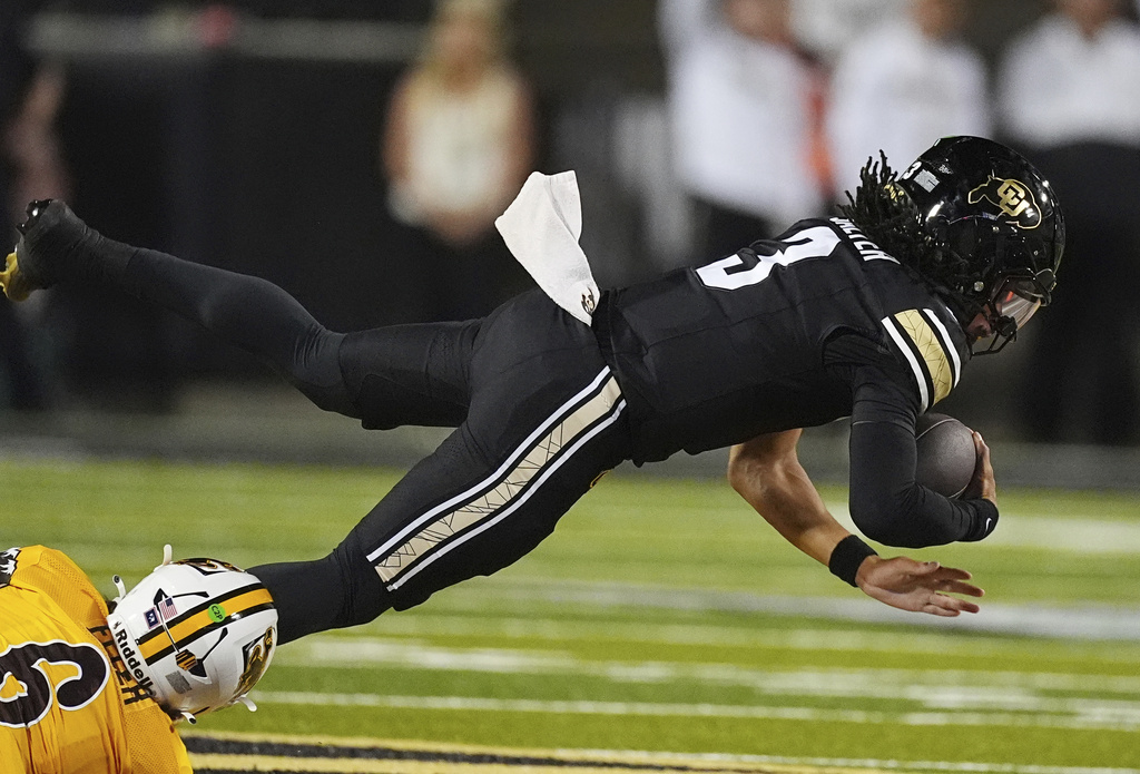 Wyoming linebacker Evan Eller, left, trips Colorado quarterback Kaidon Salter after a short gain in the first half of an NCAA college football game Saturday, Sept. 20, 2025, in Boulder, Colo. (AP Photo/David Zalubowski)