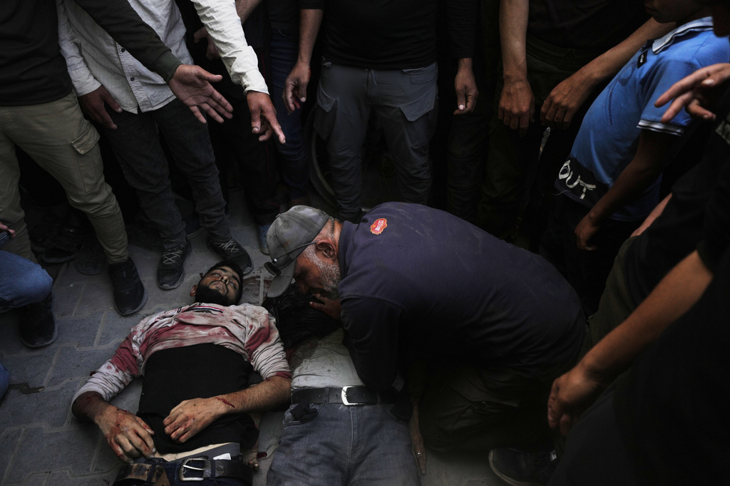 EDS NOTE: GRAPHIC CONTENT - Palestinians gather around the bodies of Iyad, Al-Shambari and his son Salah, who were killed in an Israeli airstrike, at Al-Shifa Hospital in Gaza City , Tuesday, April 28, 2026 (AP Photo/Jehad Alshrafi)