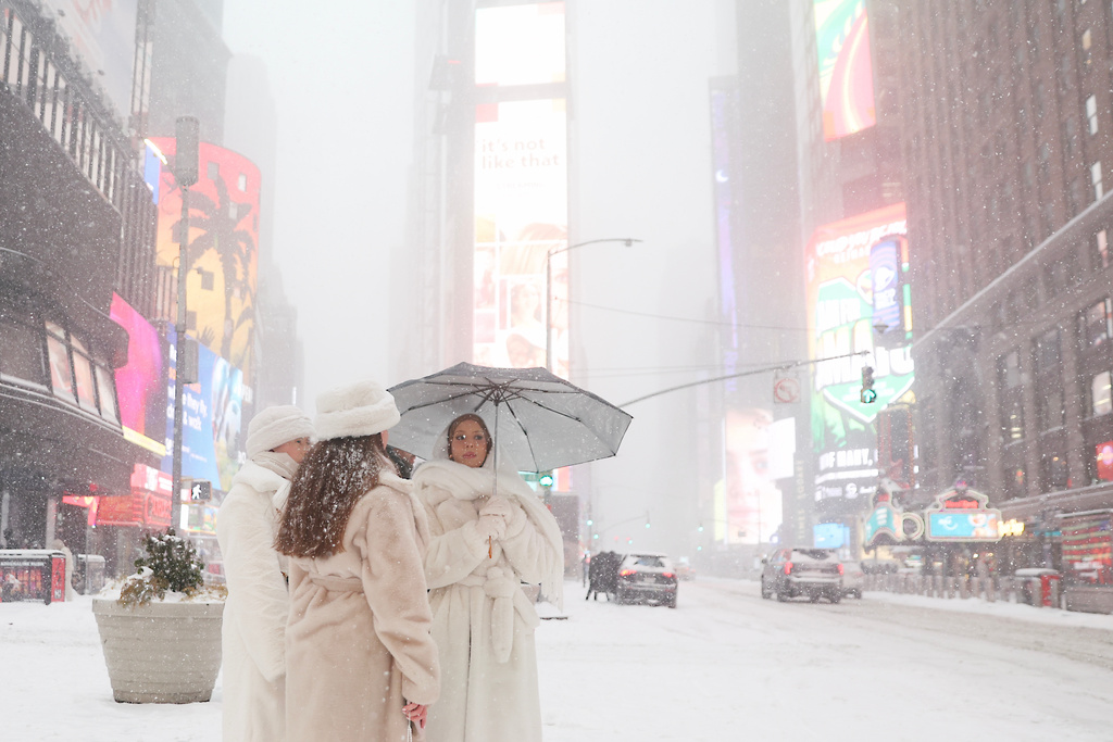 People wait to cross the street in Times Square during a winter storm, Sunday, Jan. 25, 2026, in New York. (AP Photo/Heather Khalifa)