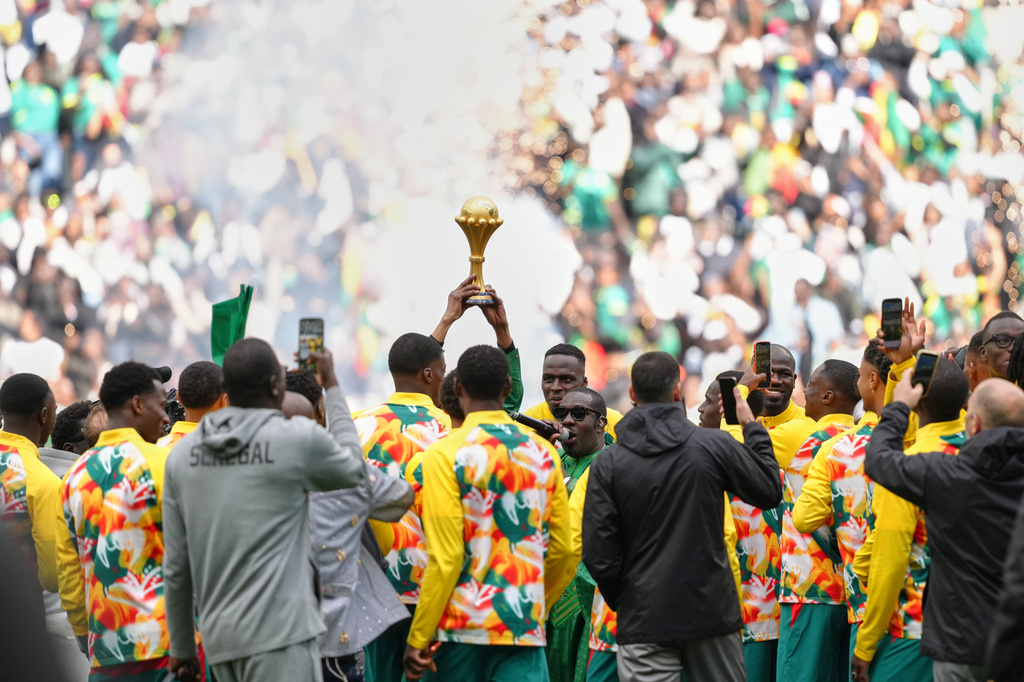 Senegal players celebrate with the Africa Cup of Nations trophy ahead of the international friendly soccer match between Senegal and Peru in Saint-Denis, outside of Paris, Saturday, March 28, 2026. (AP Photo/Aurelien Morissard)