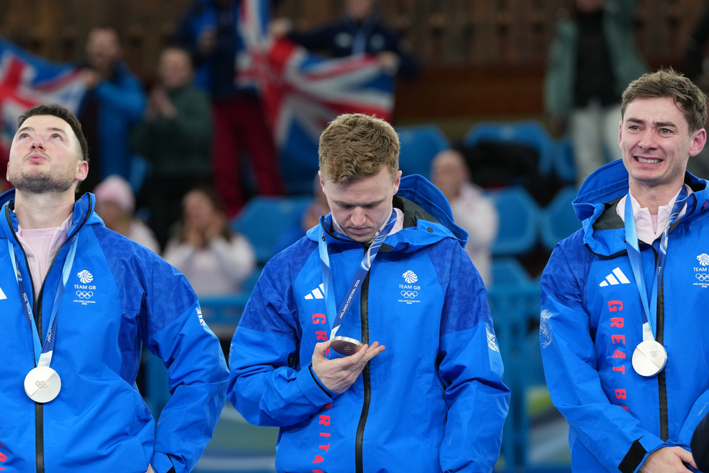 From left, Britain's Hammy McMillan, Bobby Lammie and Grant Hardie pose with the silver medals of the men's curling, at the 2026 Winter Olympics, in Cortina d'Ampezzo, Italy, Saturday, Feb. 21, 2026. (AP Photo/Misper Apawu)