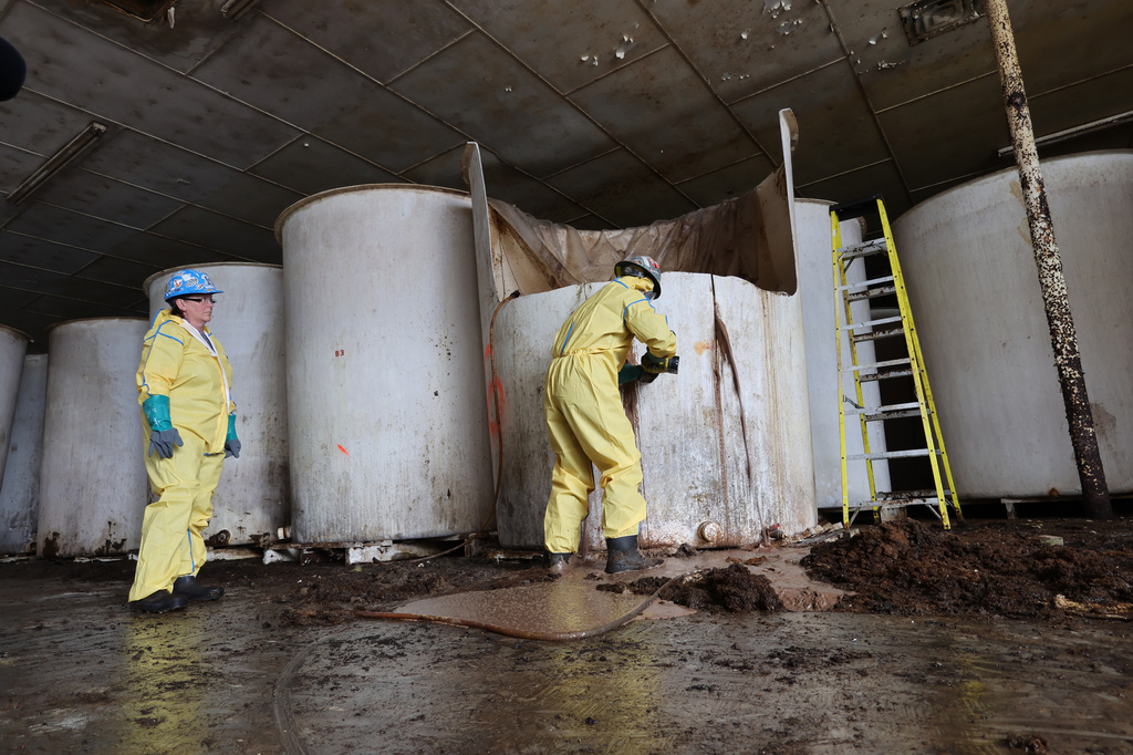Sludge pours out of a vat of fermenting fish sauce in an abandoned fish sauce factory in St. Mary's, N.L., on Tuesday July 28, 2026. (Elling Lien/The Canadian Press via AP)