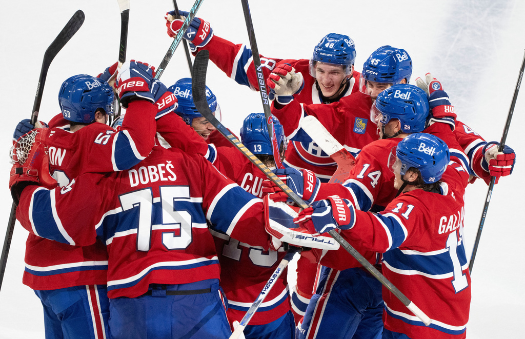 Montreal Canadiens' Cole Caufield (13) is surrounded by teammates after his winning goal over the Nashville Predators during overtime NHL hockey game action in Montreal, Thursday, Oct. 16, 2025. (Christinne Muschi/The Canadian Press via AP)