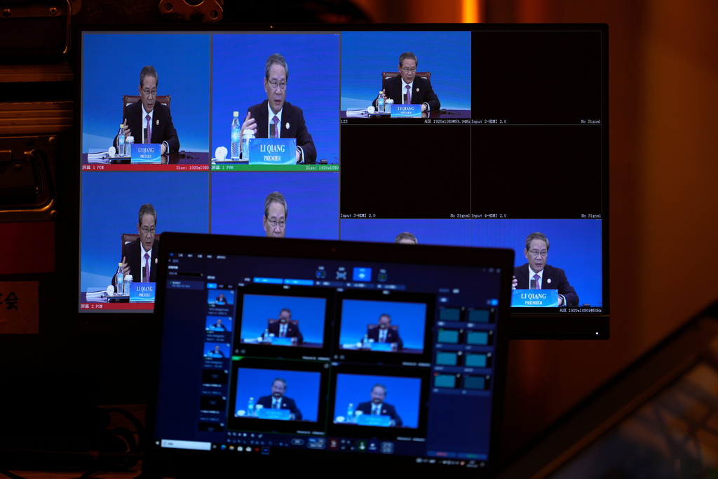 Chinese Premier Li Qiang is seen on screens during the 1+10 Dialogue with heads of major international economic organizations in Beijing, China, Tuesday, Dec. 9, 2025. (AP Photo/Ng Han Guan)