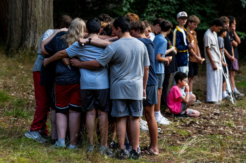 Community members gather during a student-organized vigil at Duncan Woods in Grand Haven, Mich. on Sunday, July 26, 2026, to grieve and honor eight members of a local family who died in a tragedy that has stunned the lakeshore community. (Isaac Ritchey/The Grand Rapids Press via AP)