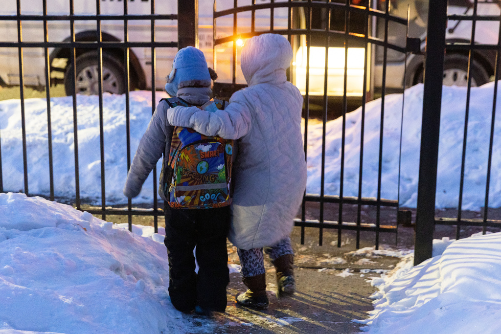 Giancarlo, 10, is escorted by his mom to the curb for bus pickup Tuesday, Feb. 3, 2026, in Minneapolis. (AP Photo/Liam James Doyle)