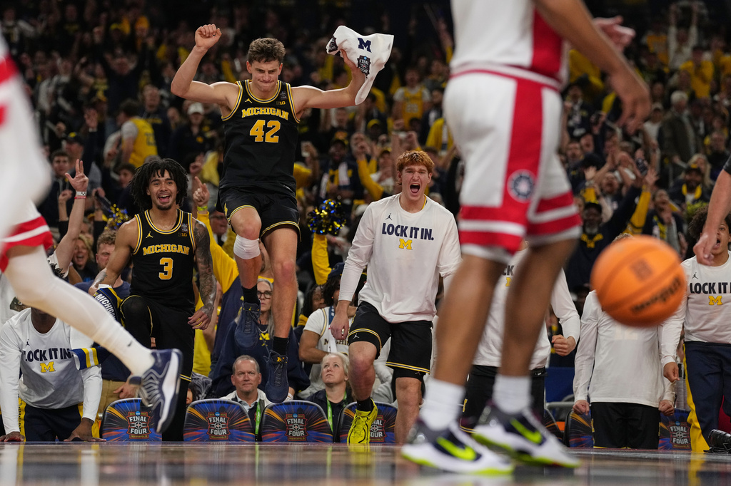 Michigan's Will Tschetter (42) and Elliot Cadeau (3) celebrate during the second half of an NCAA college basketball tournament semifinal game against Arizona at the Final Four, Saturday, April 4, 2026, in Indianapolis. (AP Photo/Michael Conroy)