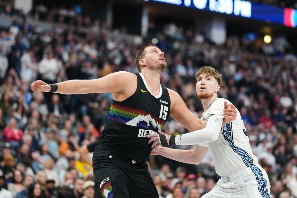 Denver Nuggets center Nikola Jokić, left, jostles for position for a rebound with Memphis Grizzlies center Lawson Lovering in the first half of an NBA basketball game Wednesday, Feb. 11, 2026, in Denver. (AP Photo/David Zalubowski)