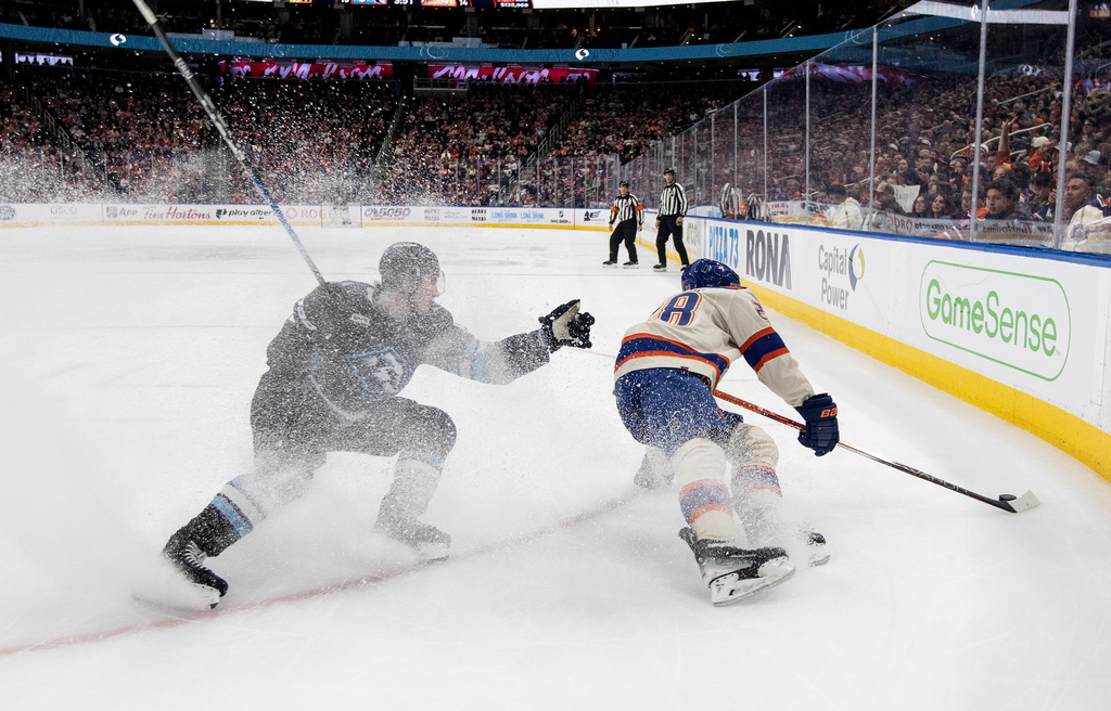 Utah Mammoth's Logan Cooley (left) chases Edmonton Oilers' Jack Roslovic (28) during second period NHL action, in Edmonton on Tuesday, Oct. 28, 2025. (Jason Franson/The Canadian Press via AP)