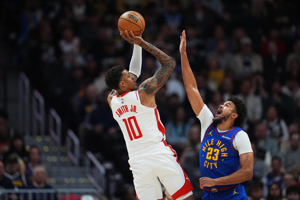 Houston Rockets forward Jabari Smith Jr., left, shoots for a basket over Denver Nuggets forward Cameron Johnson in the first half of an NBA basketball game Wednesday, March 11, 2026, in Denver. (AP Photo/David Zalubowski)