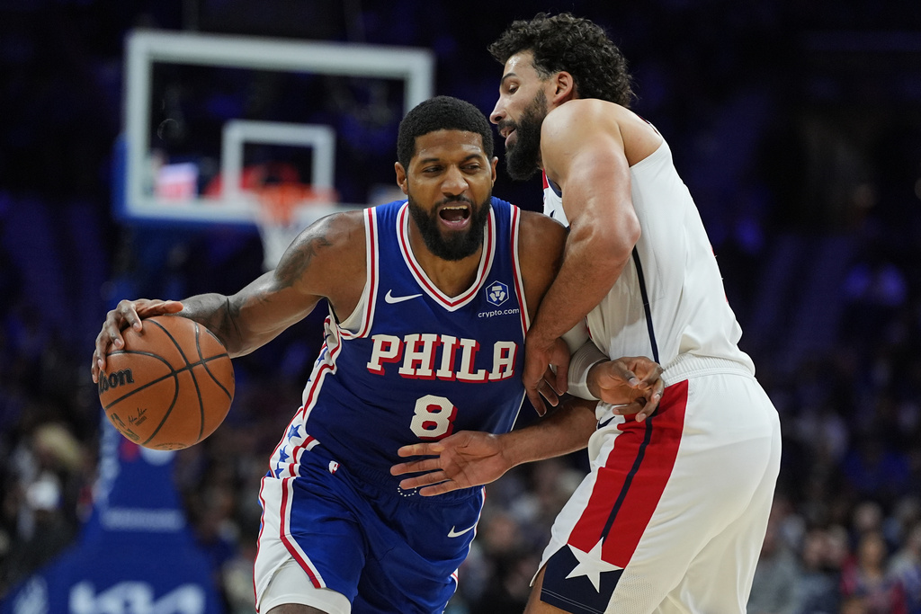 Philadelphia 76ers' Paul George (8) tries to get a shot past Washington Wizards' Anthony Gill during the second half of an NBA basketball game Wednesday, Jan. 7, 2026, in Philadelphia. (AP Photo/Matt Rourke)