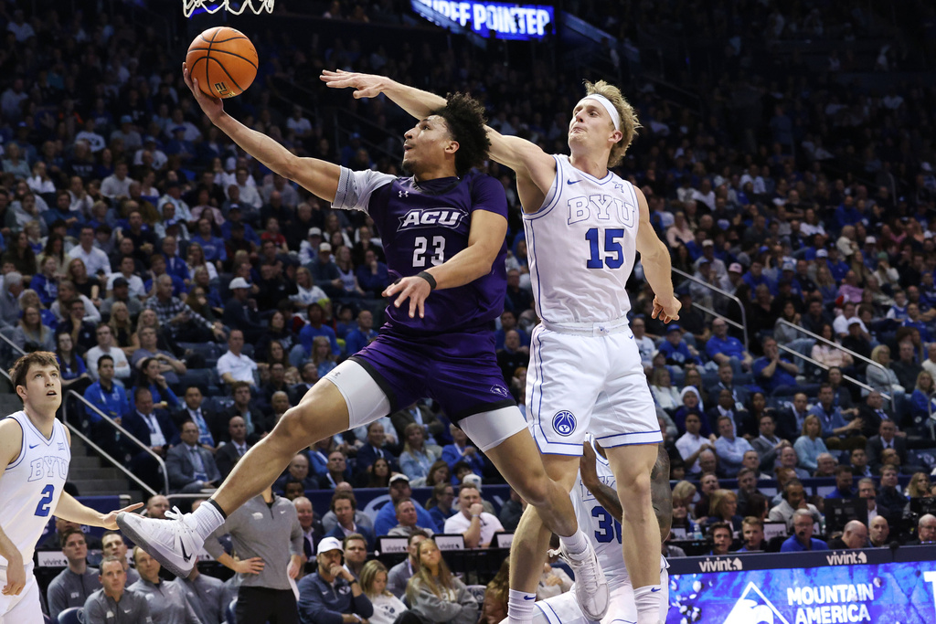 Abilene Christian guard Joseph Venzant drives on BYU guard Richie Saunders during the first half of an NCAA college basketball game, Friday, Dec. 19, 2025, in Provo, Utah. (AP Photo/Jeffrey D. Allred)