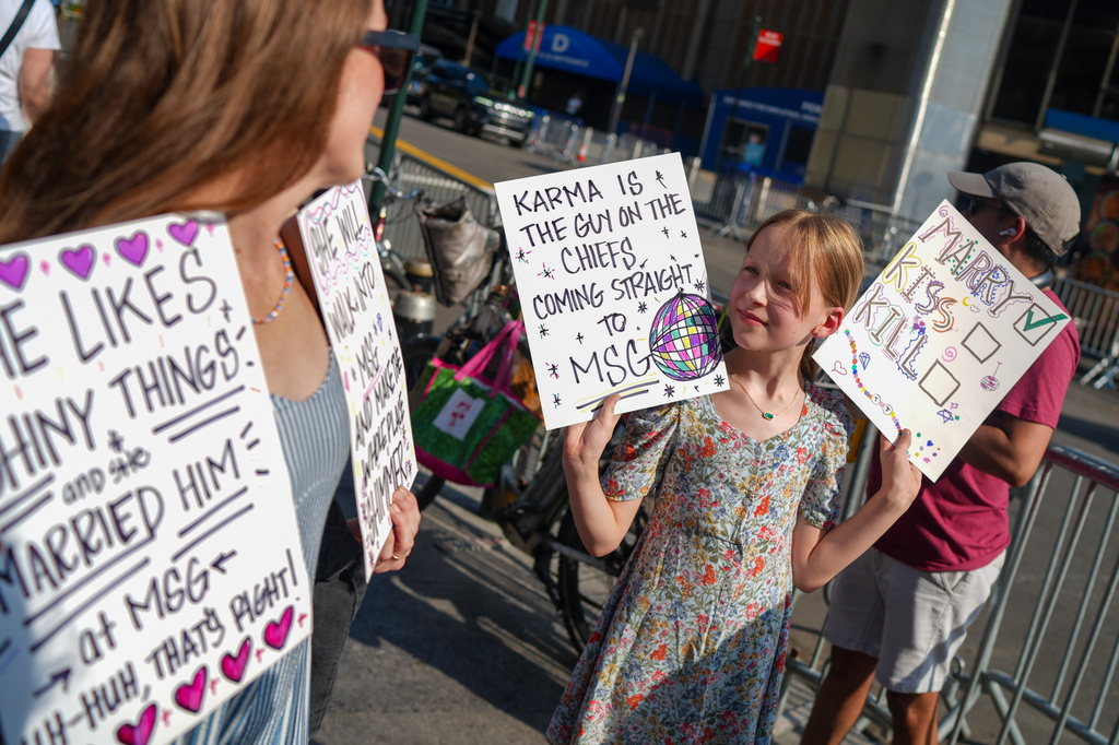 Taylor Swift fans hold signs outside of Madison Square Garden ahead of a reported wedding between singer Taylor Swift and National Football League player Travis Kelce on Friday, July 3, 2026, in New York. (AP Photo/Ryan Murphy)