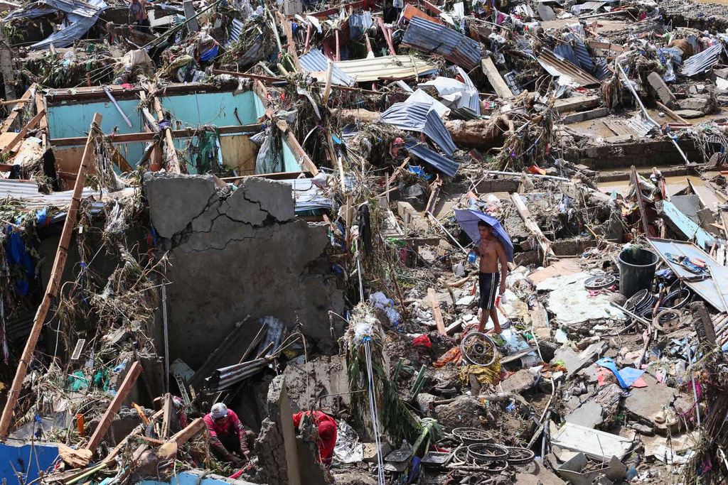 Residents return to their damaged homes after Typhoon Kalmaegi caused devastation in communities along the Mananga River in Talisay City, Cebu province, central Philippines, Wednesday, Nov. 5, 2025. (AP Photo/Jacqueline Hernandez)