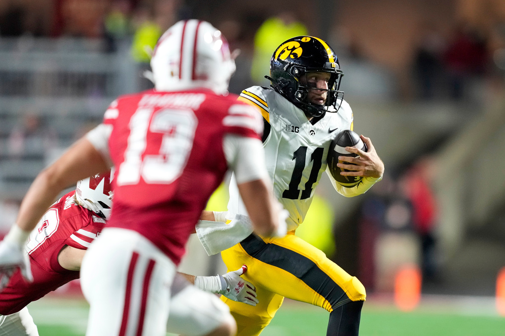 Iowa quarterback Mark Gronowski (11) scrambles against Wisconsin during the second half of an NCAA college football game Saturday, Oct. 11, 2025, in Madison, Wis. (AP Photo/Andy Manis)
