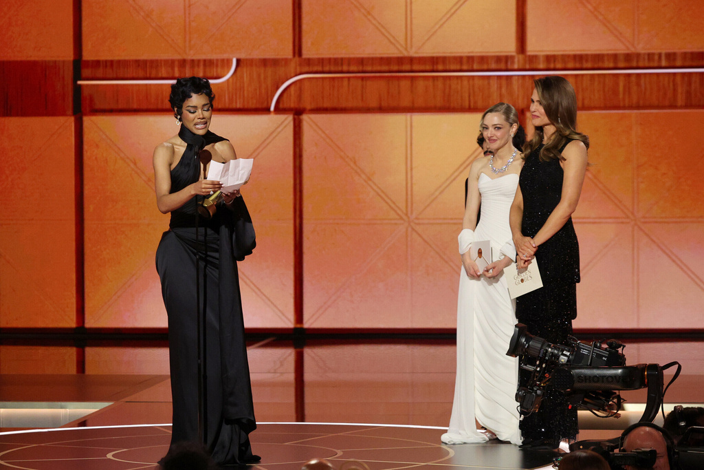 This image released by CBS Broadcasting shows Teyana Taylor, left, accepting the award for best performance by a supporting actress in a motion picture for "One Battle After Another" as presenters Amanda Seyfried and Jennifer Garner, right, look on during the 83rd Golden Globes on Sunday, Jan. 11, 2026, at the Beverly Hilton in Beverly Hills, Calif. (Kevork Djansezian/CBS Broadcasting via AP)