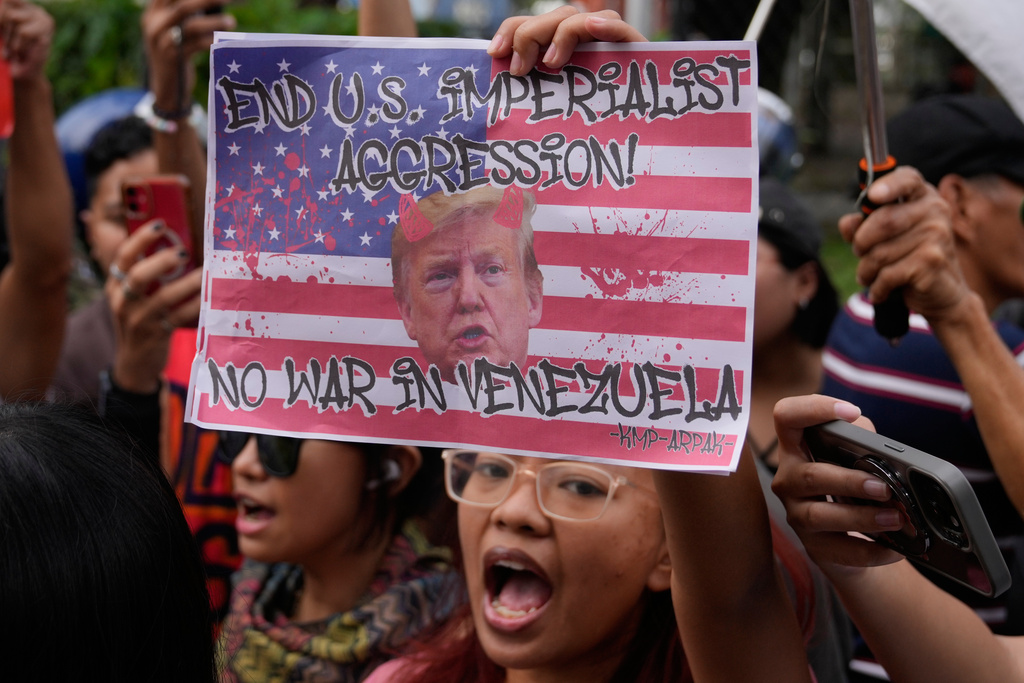 Protesters shout slogans while holding a picture of U.S. President Donald Trump as they denounce the U.S. government and Trump after the U.S. captured Venezuelan President Nicolas Maduro during a rally near the U.S. Embassy in Manila, Philippines on Monday, Jan. 5, 2026. (AP Photo/Aaron Favila)