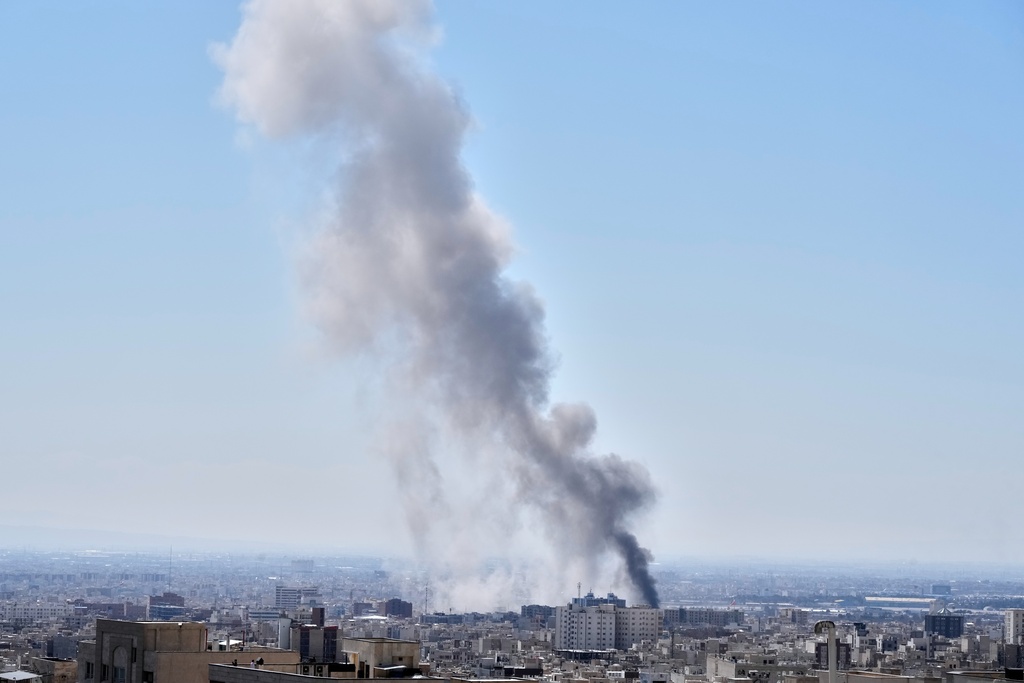 A plume of smoke rises after a strike in Tehran, Iran, Sunday, March 1, 2026. (AP Photo/Vahid Salemi)