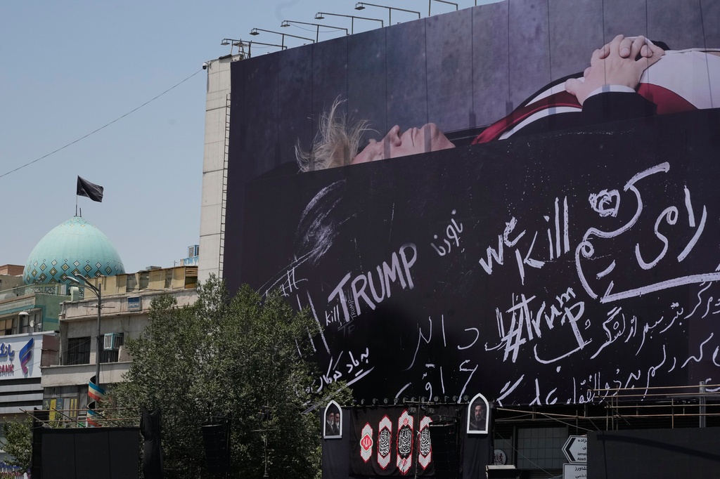 A billboard depicting U.S. President Donald Trump lying on what appears to be a coffin and bearing anti-Trump messages, including the phrase "We Kill Trump," is seen at Islamic Revolution Square in downtown Tehran, Iran, Wednesday, July 15, 2026. (AP Photo/Vahid Salemi)