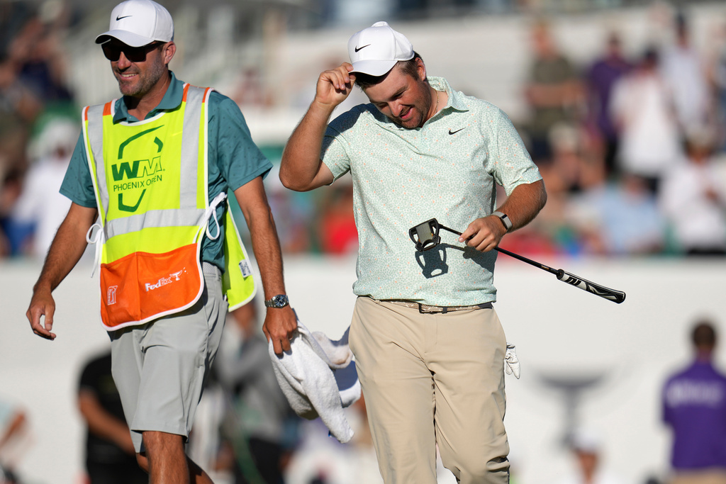 Chris Gotterup, right, smiles along with caddie Brady Stockton after Gotterup's playoff win on the 18th hole during the final round of the Phoenix Open golf tournament Sunday, Feb. 8, 2026, in Scottsdale, Ariz. (AP Photo/Ross D. Franklin)